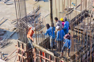 worker-pouring-cement-pouring-into-foundations-pillars-formwork-area-construction-site_25169-295